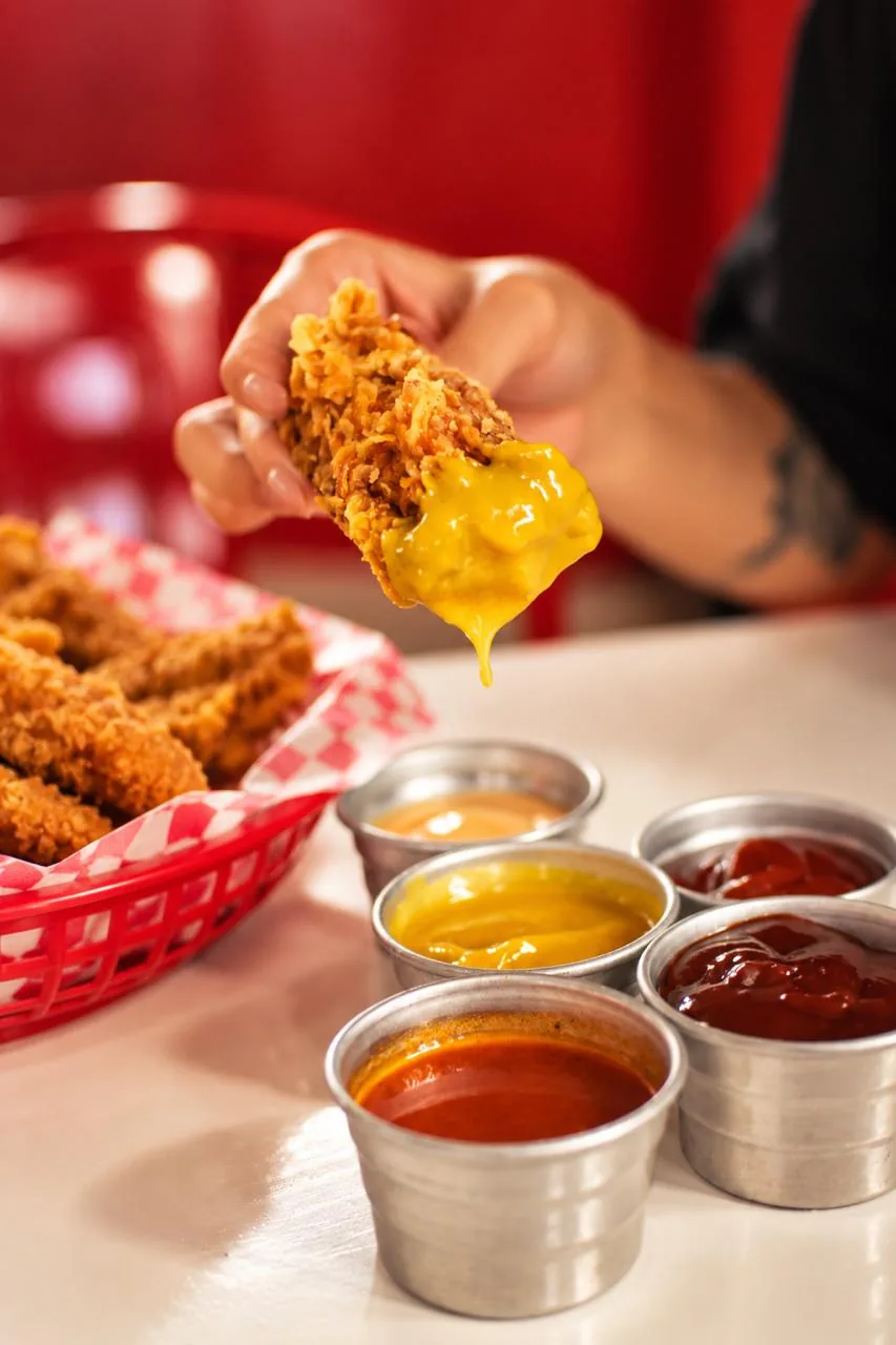 Bastoncito de pollo crujiente bañado en cheddar, con las salsas de PFC.
