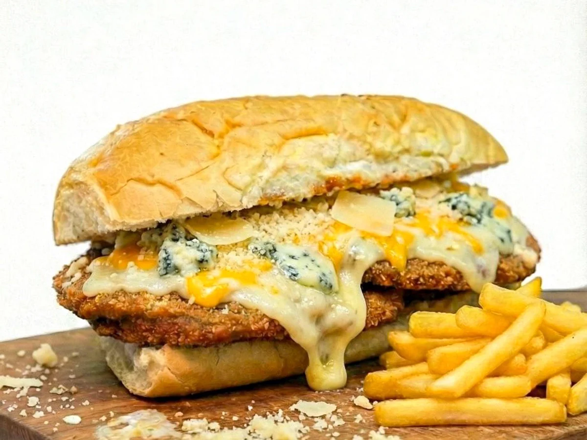 Sándwich de milanesa con mozzarella, roquefort, parmesano y cheddar.