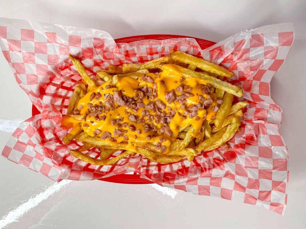 Papas fritas con cheddar y trocitos de bacon.