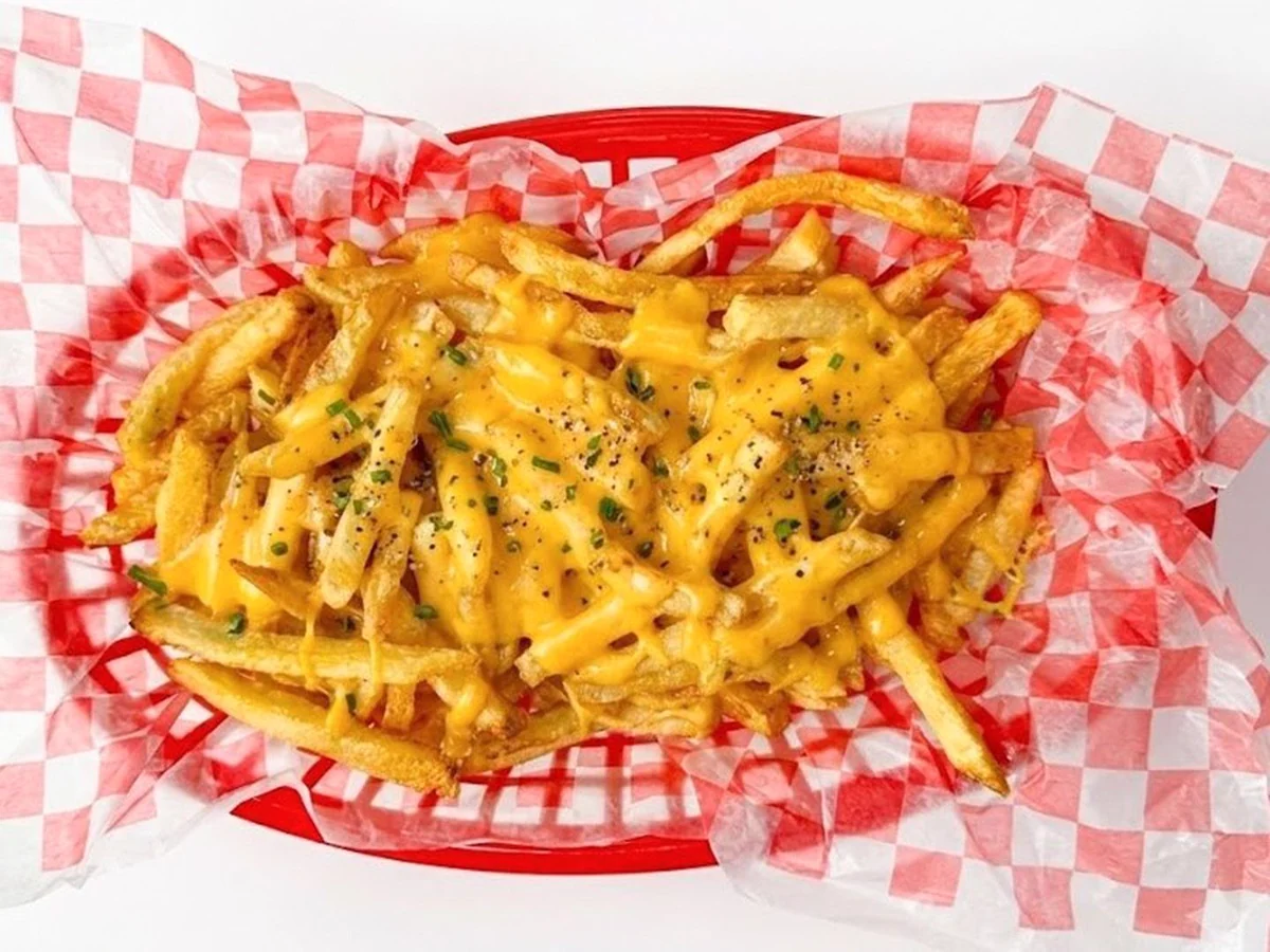 Papas fritas cubiertas con cheddar.